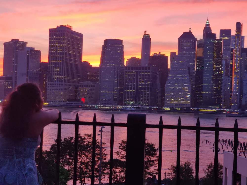 Eshika, the author, looking at the New York City skyline at sunset.
