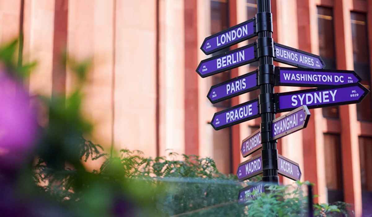 A street sign signaling the direction of NYUʼs global academic centers and programs.