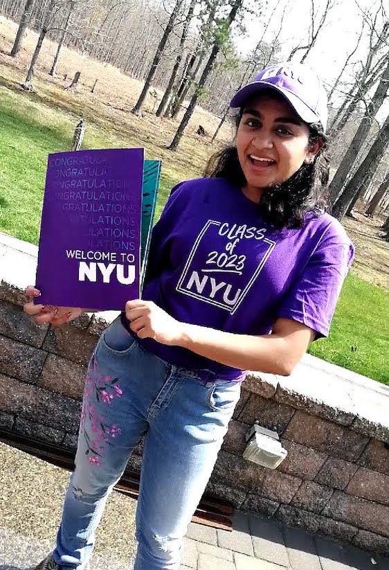 Eshika wearing NYU purple and showing off her school pride.