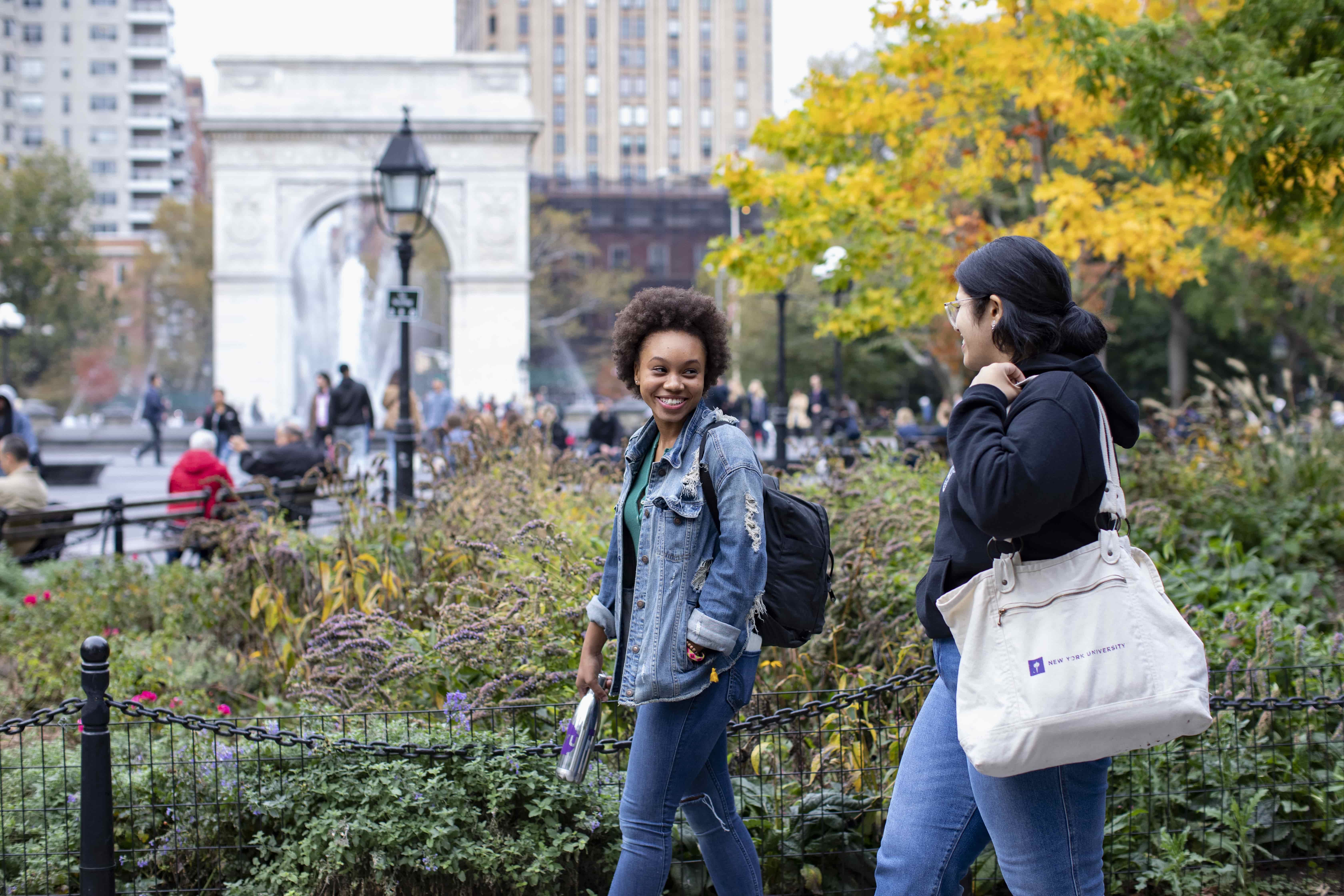 Two female students walking in Washington Square Park