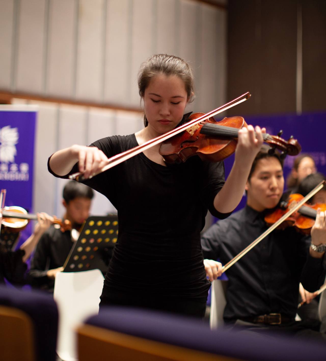 Jaime Cantwell playing her violin with an orchestra