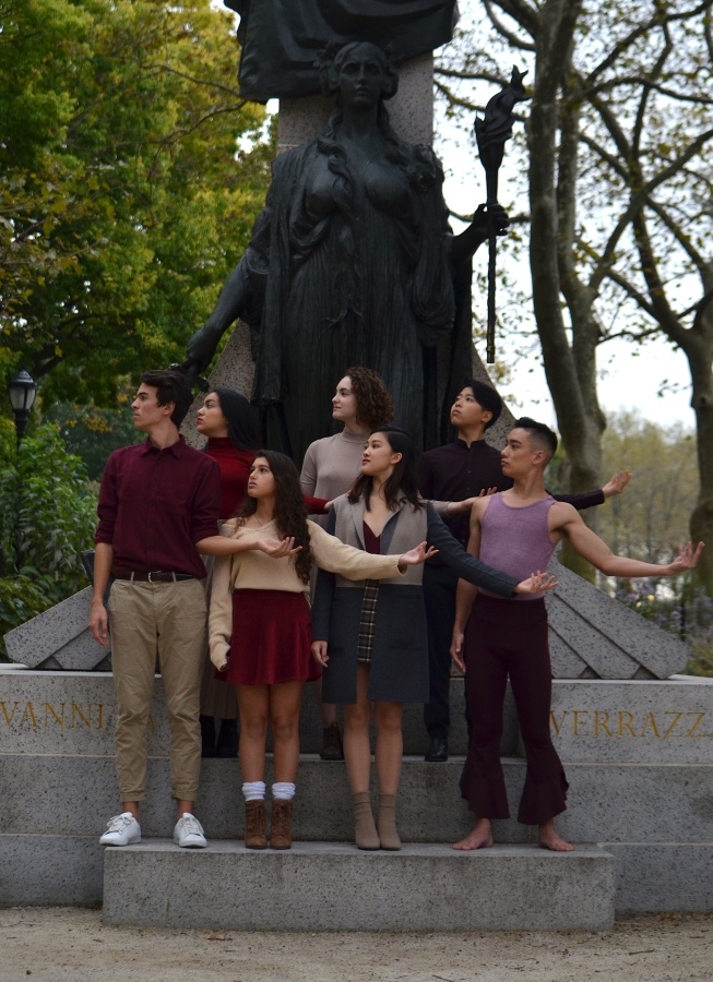 A group of students posing in front of a statue.