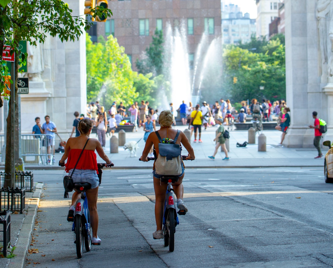 Two people riding their bikes toward Washington Square Park.