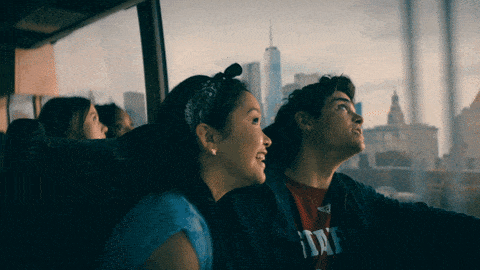 Tw people looking at New York City from a bus window.
