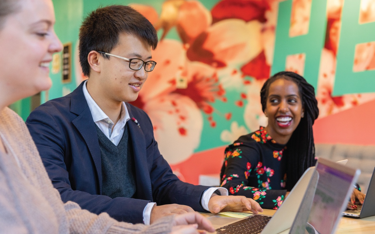 Students seated at a desk and working together