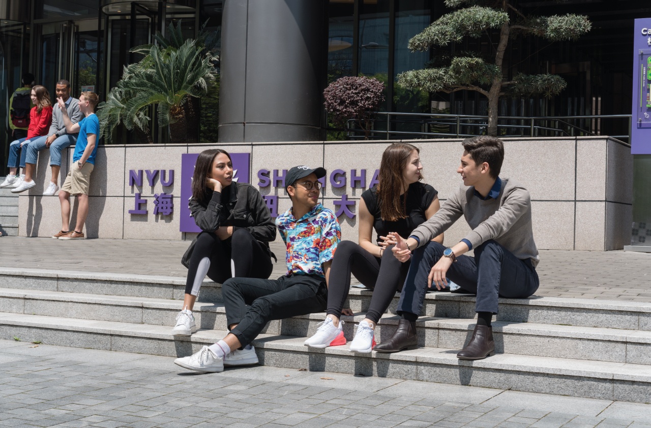 Students sitting in front of NYU Shanghaiʼs campus.