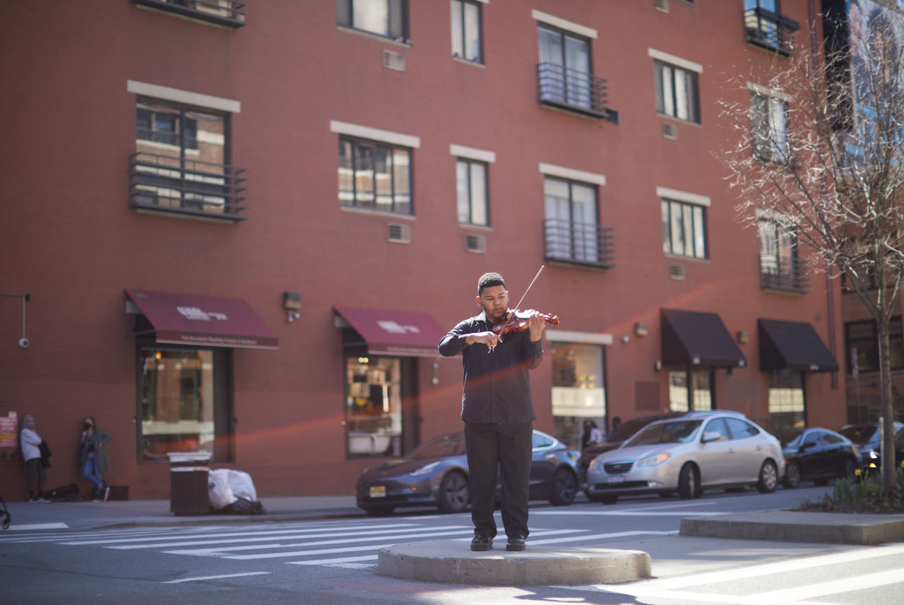 A man playing a violin in the street.