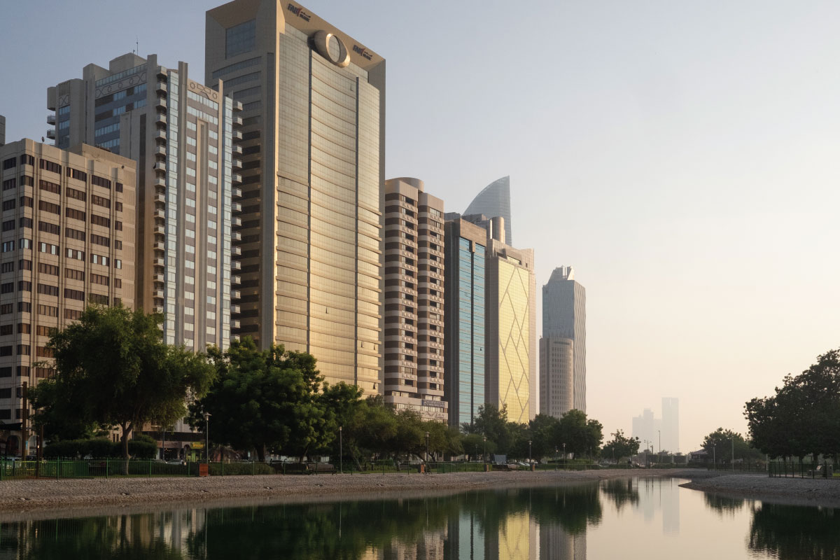 A skyline view of Abu Dhabi along a body of water.