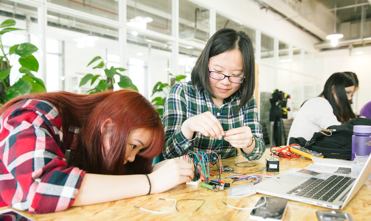 Two students working on a circuit board