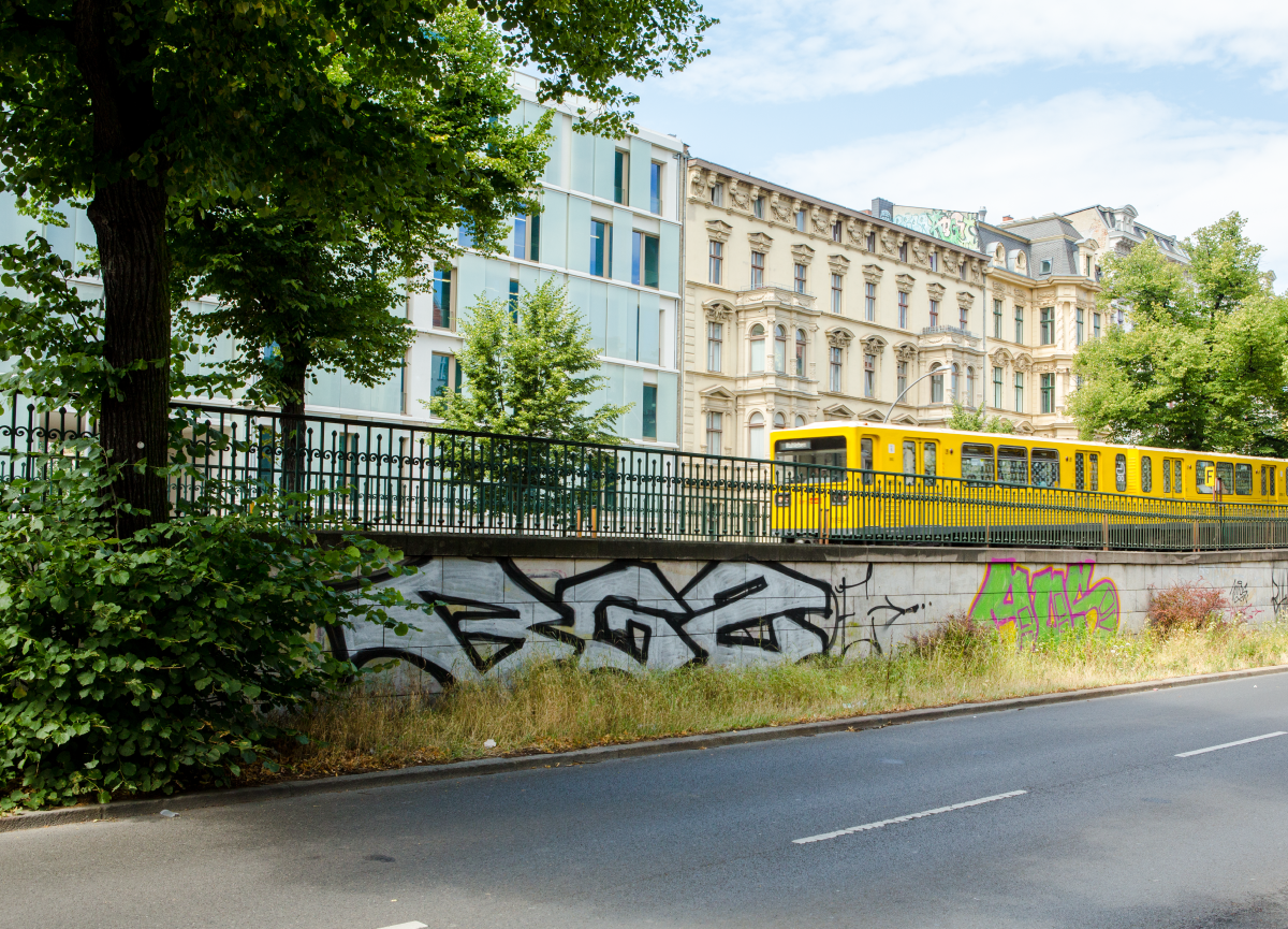 An above-ground train passing through a Berlin neighborhood.