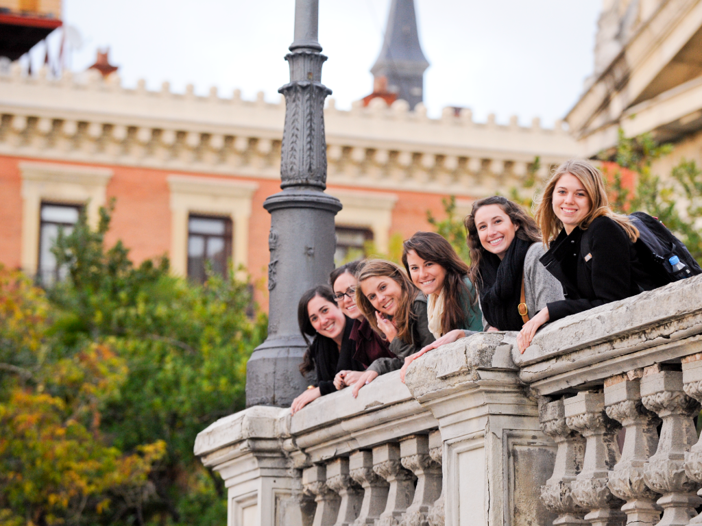 A group of NYU students lean on a balcony in NYU Madrid