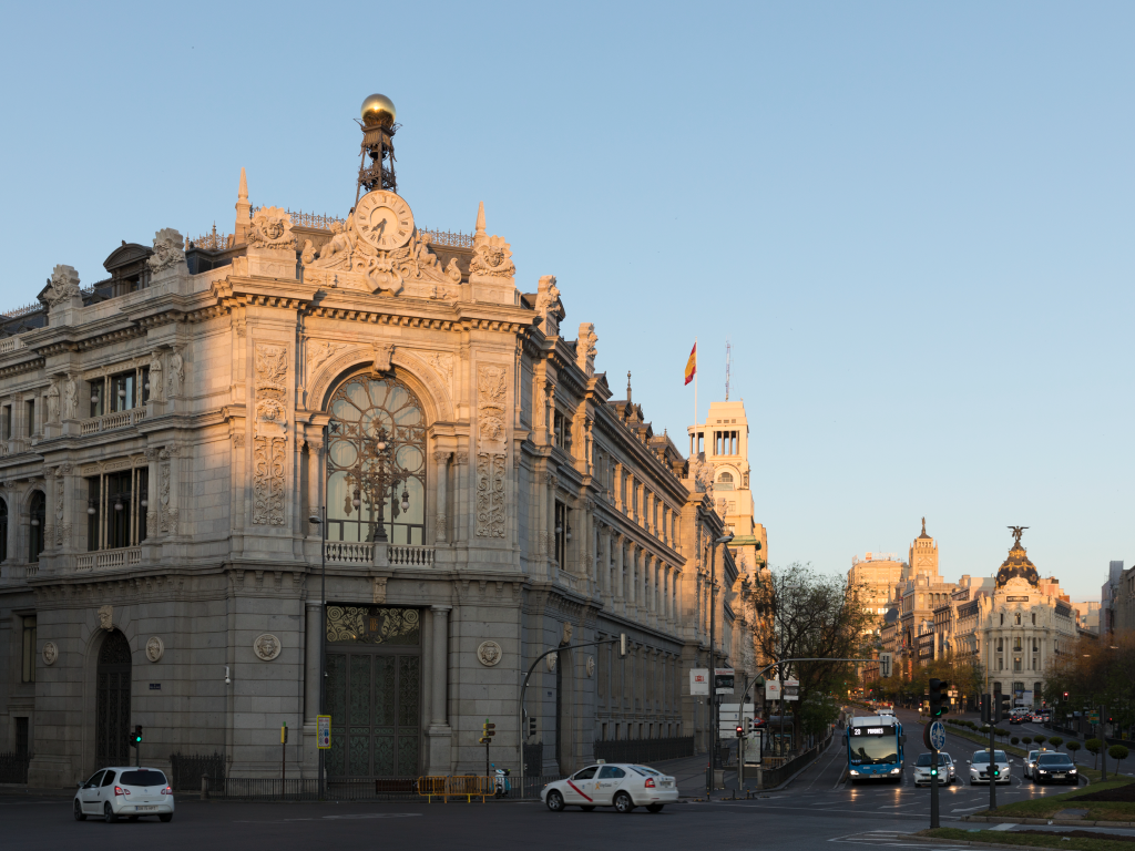 A street in central Madrid with the Metropolis Building visible in the distance.