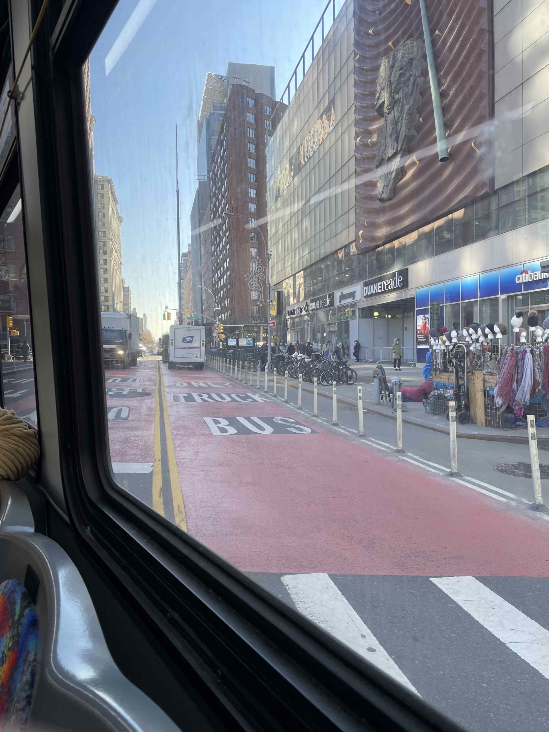 A busy street viewed from an NYU bus window.