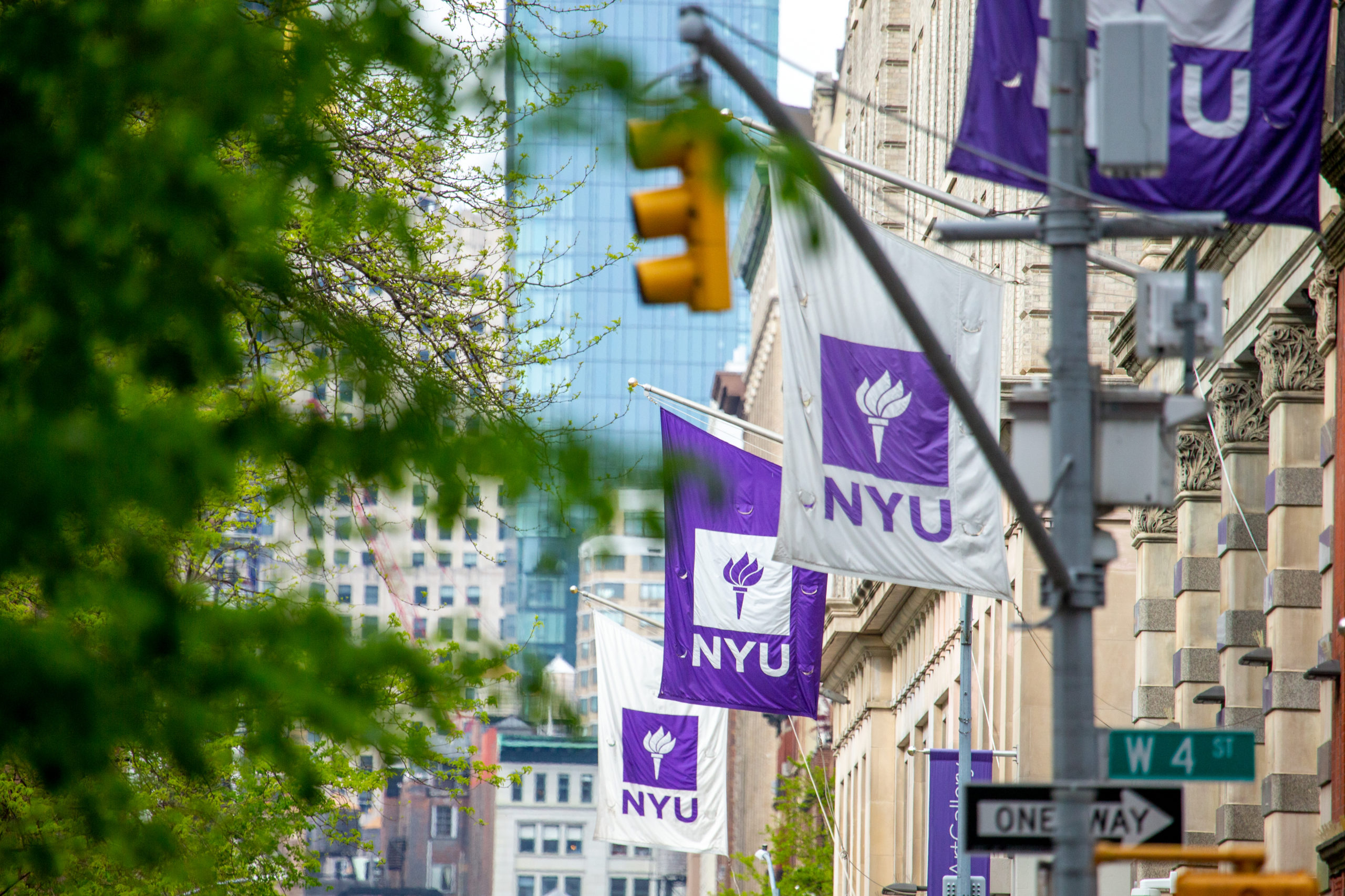 A series of NYU flags on buildings in New York City.