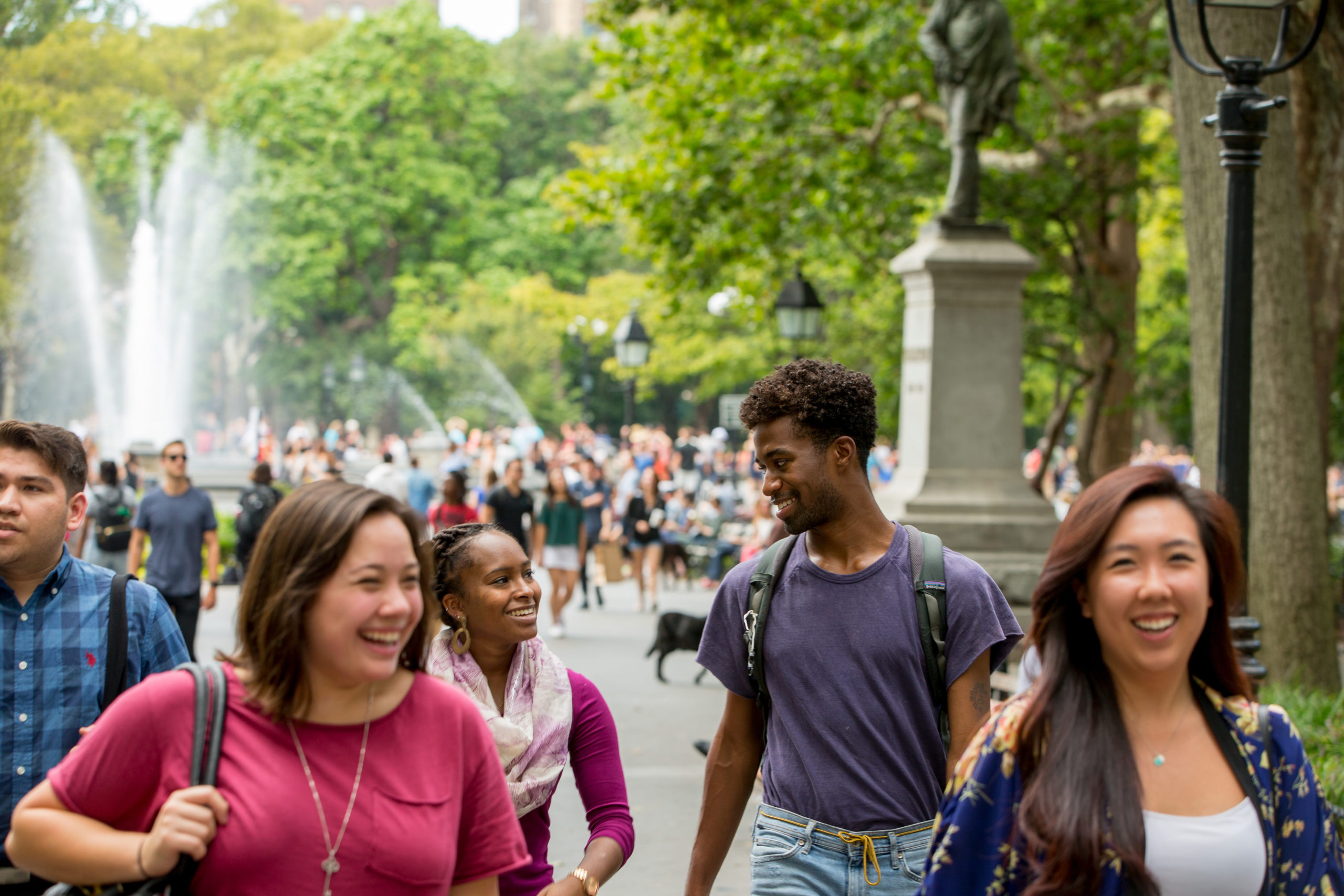 A group of NYU students walking through Washington Square Park.