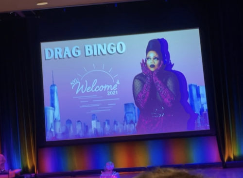 An image for Drag Bingo is projected on stage during the event