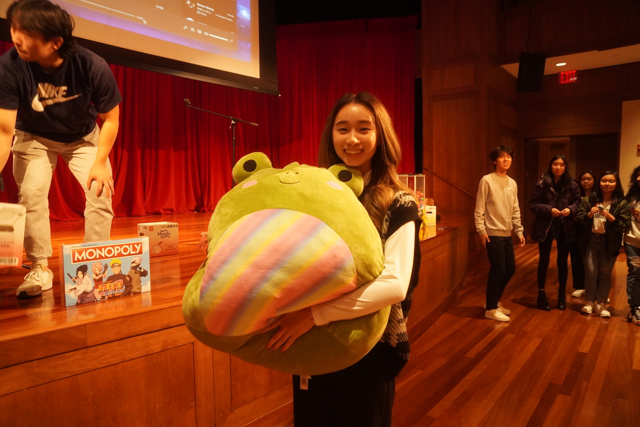 A student smiling and hugging a large plush prize.