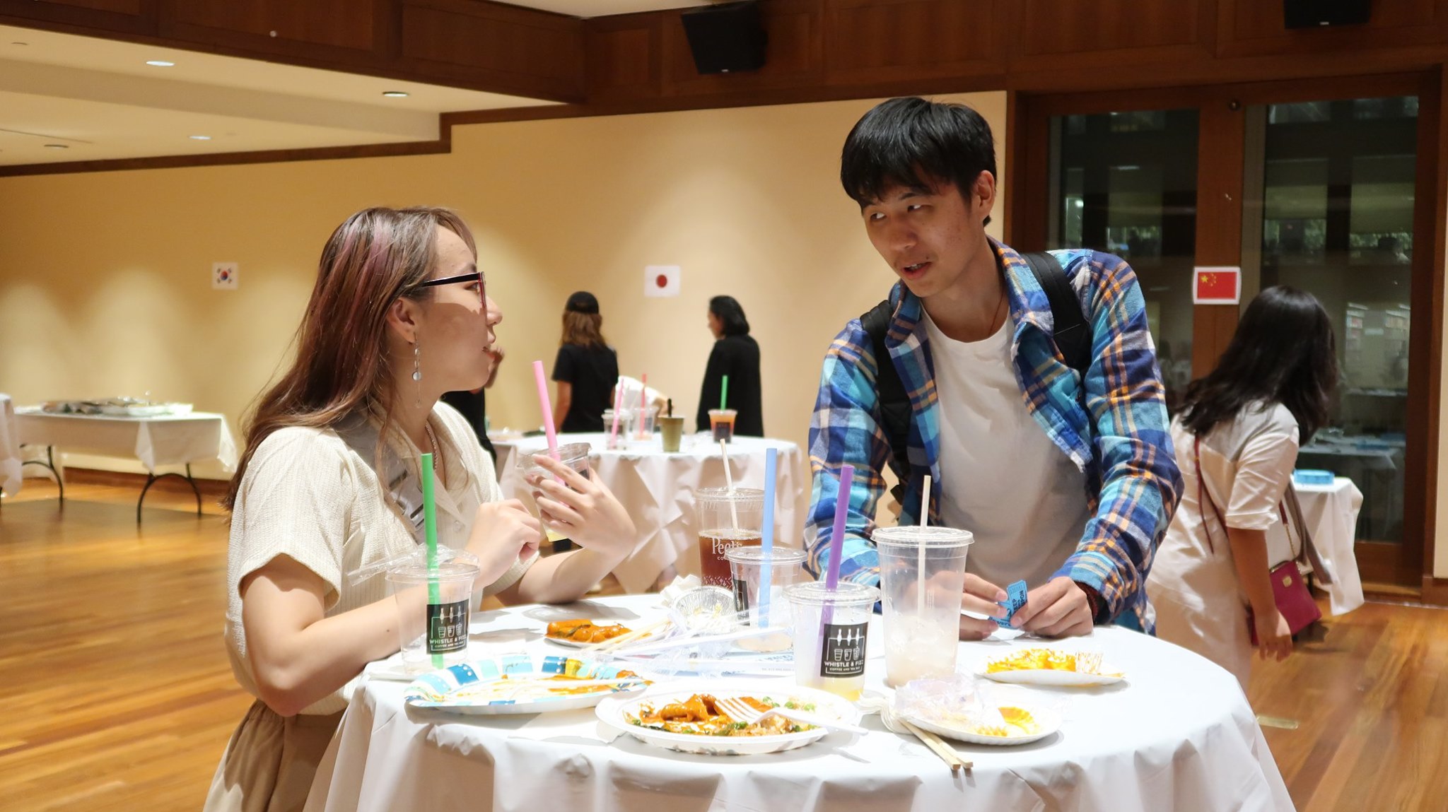 Two students talking at a table during the event.