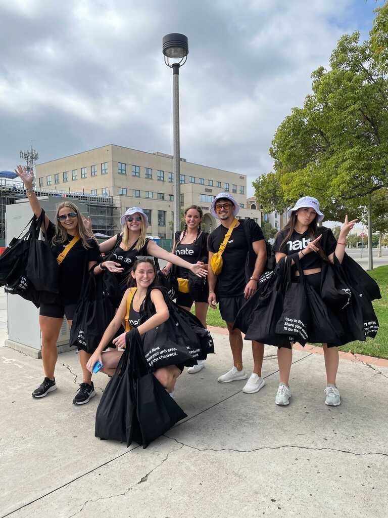 A group of students holding swag bags and wearing hats
