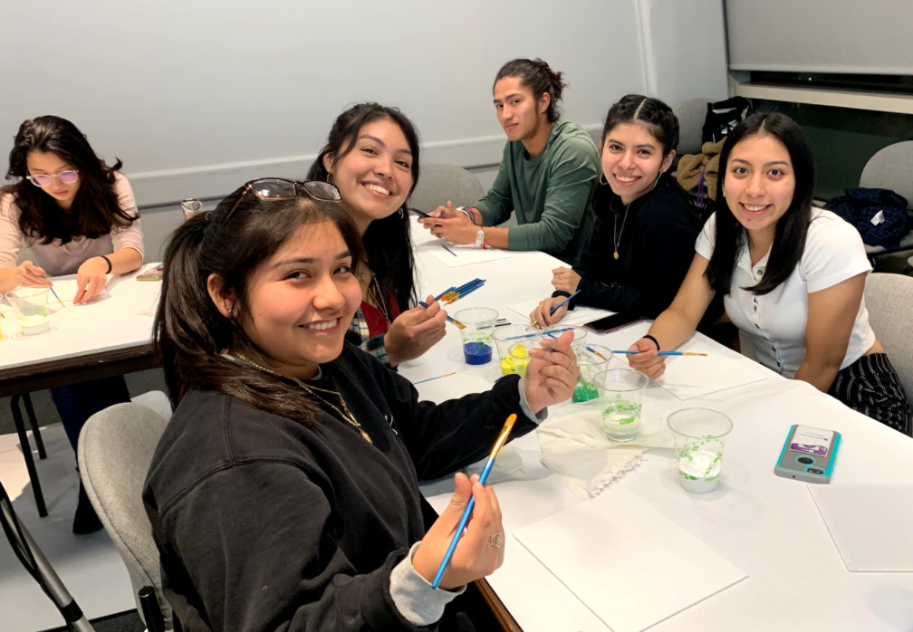 Students at a table enjoying a paint-and-sip Hispanic culture event.