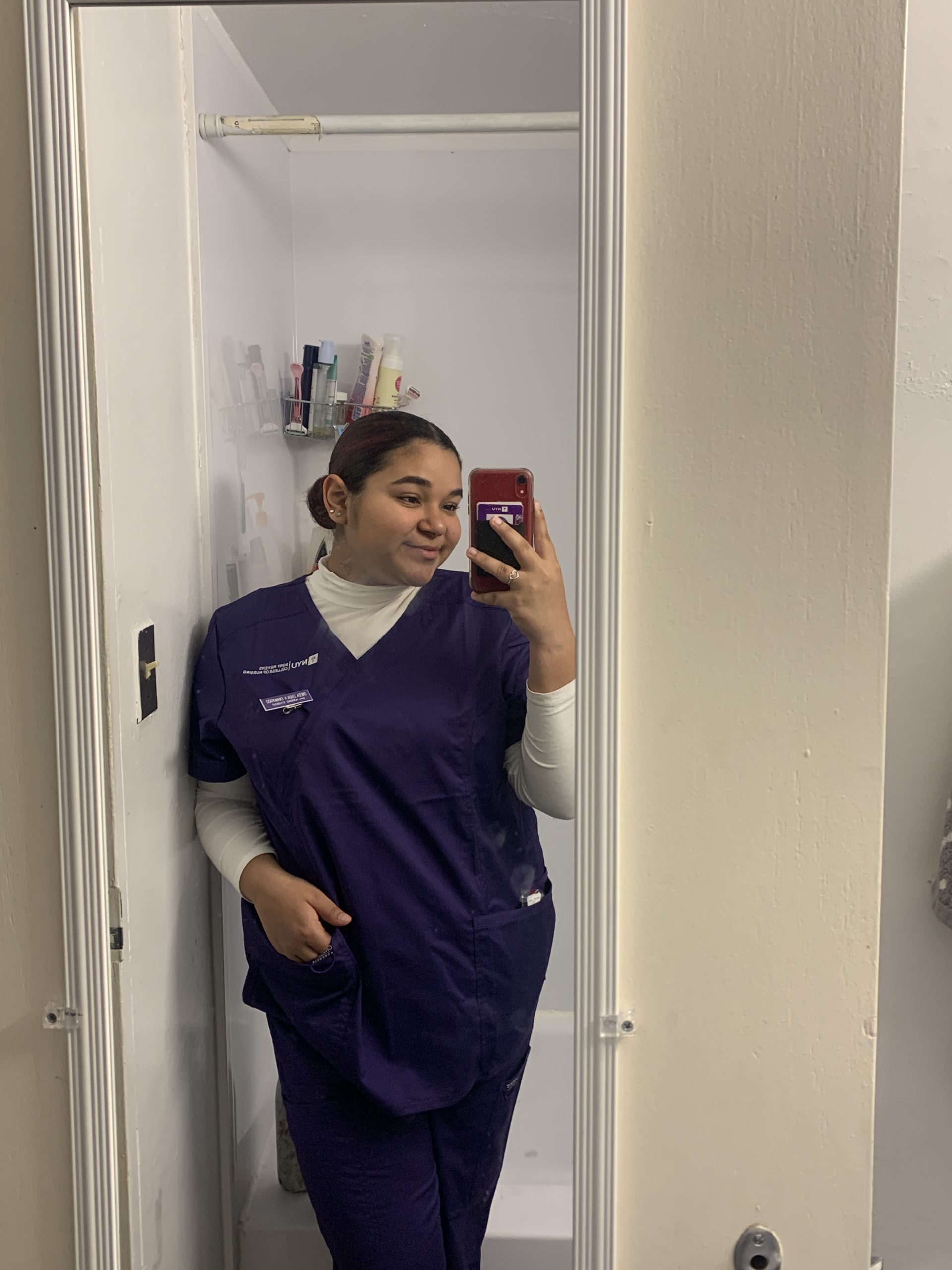 NYU nursing student in scrubs.