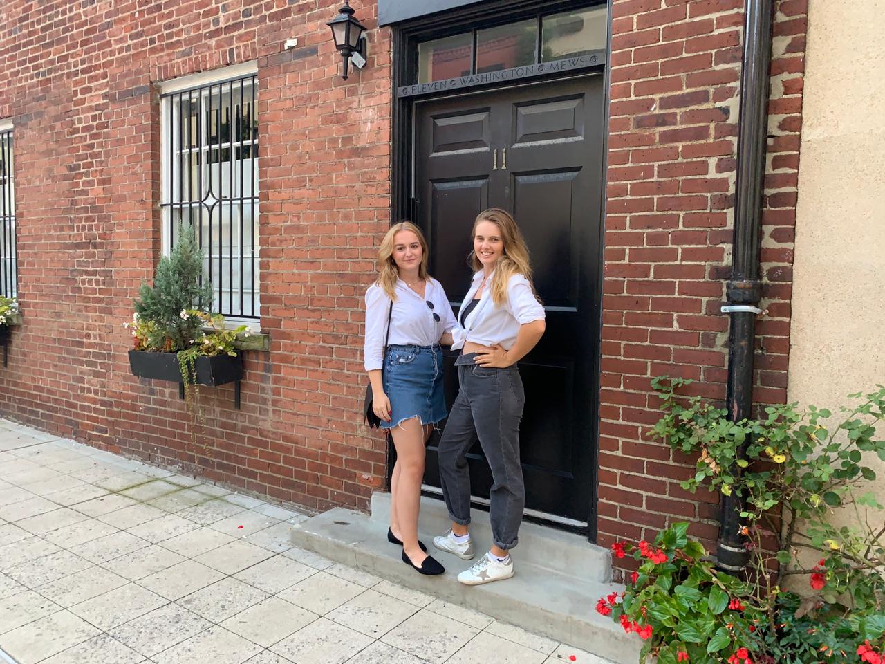 Two European Society students standing outside the door of a brick building.