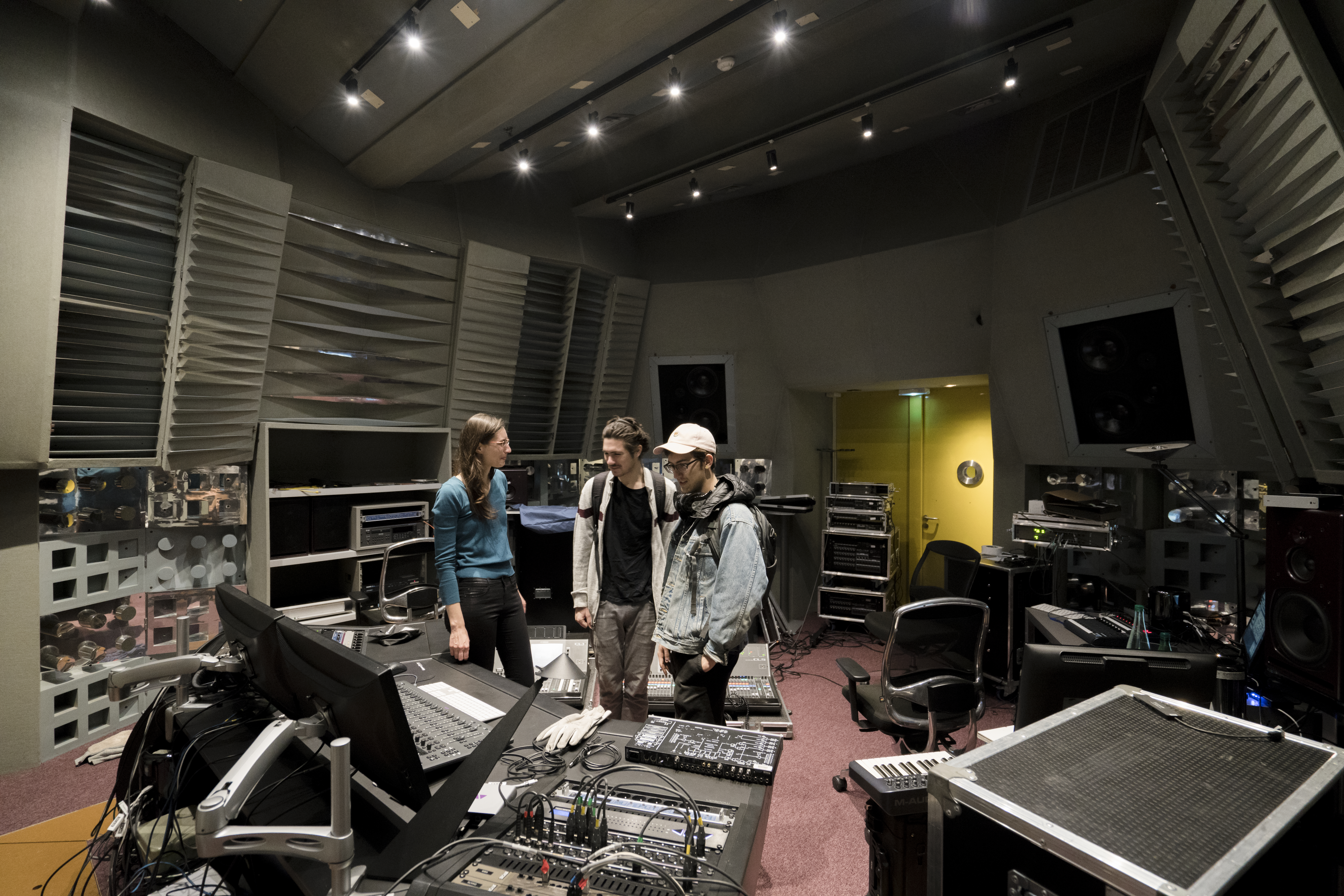 Students standing in a music recording space.