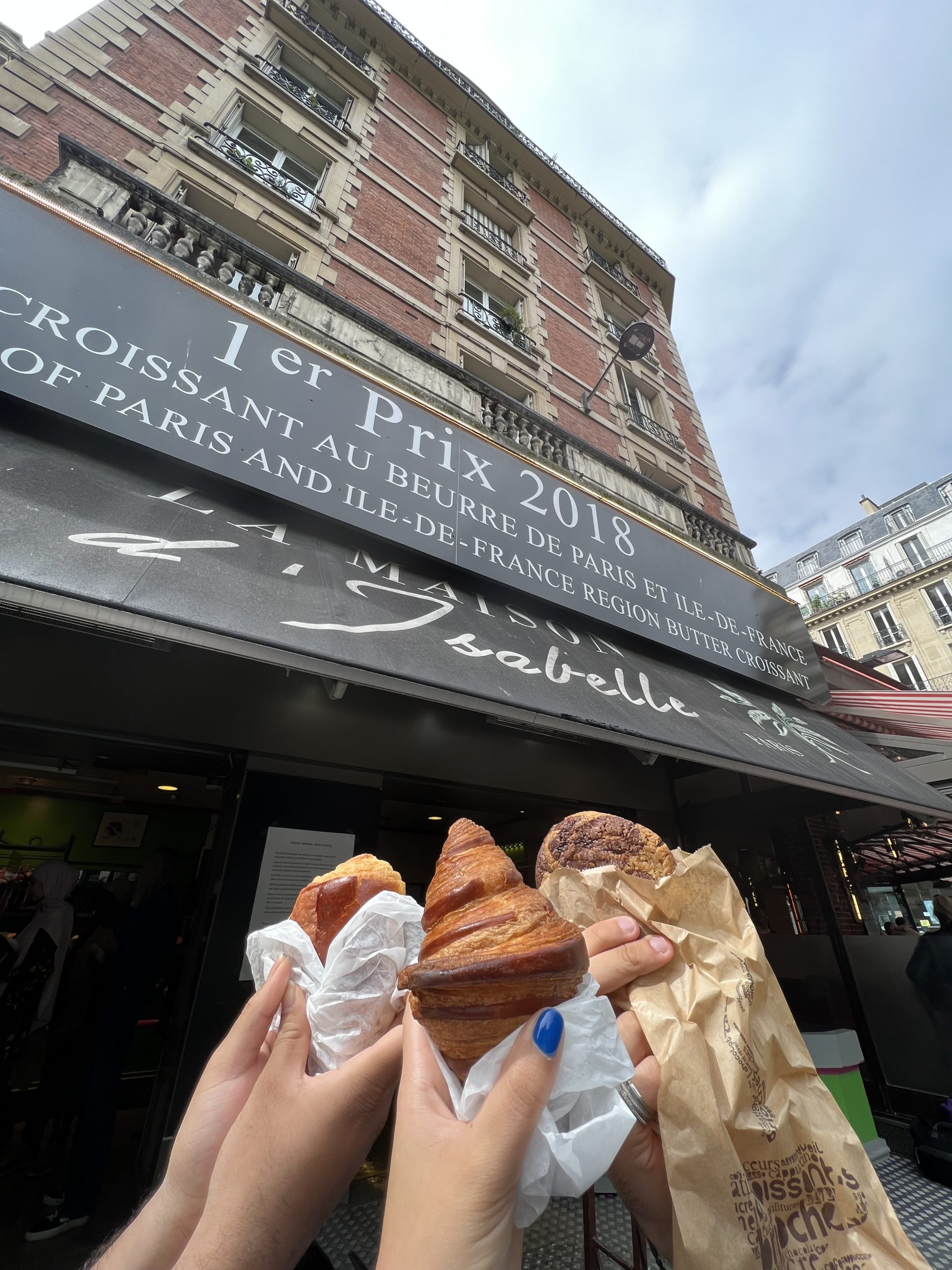 three hands hold up Croissants