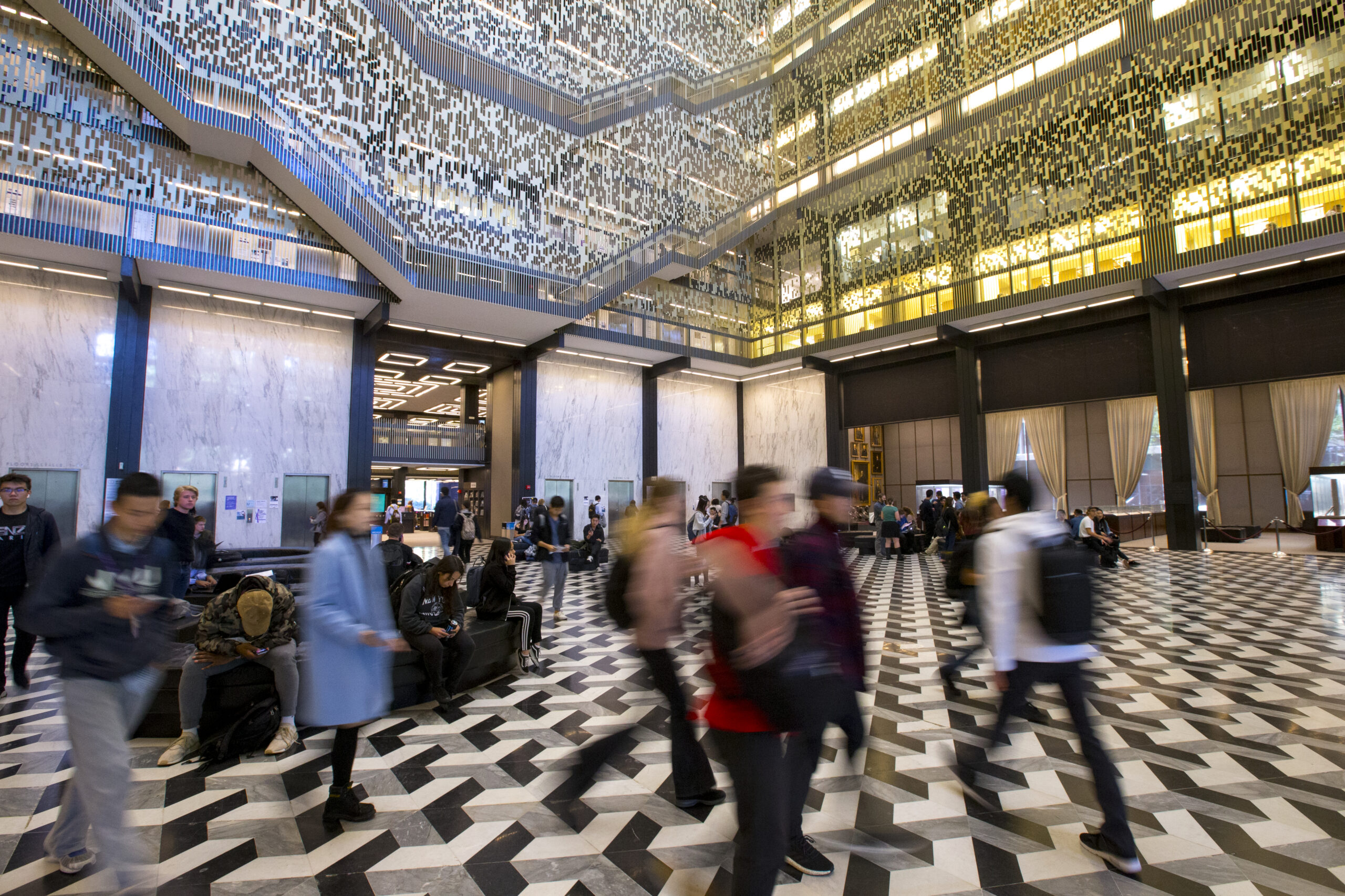 Students passing through the lobby of Bobst Library.