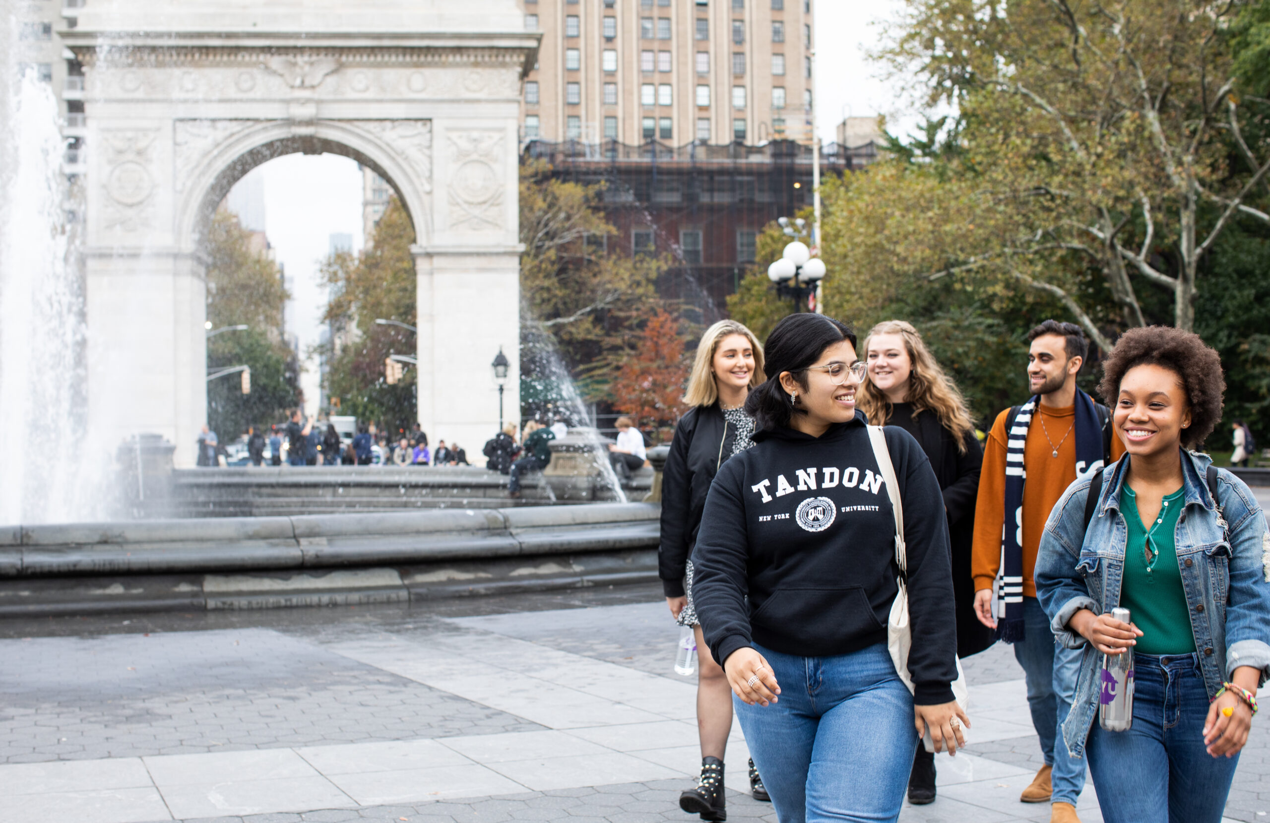 A group of students passing through Washington Square Park together.