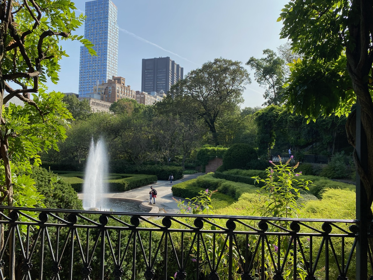 A water fountain flowing within a lovely green area of Central Park