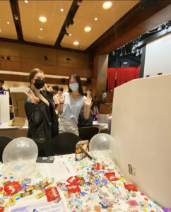 Two students behind a table filled with candy at Club Fest. 
