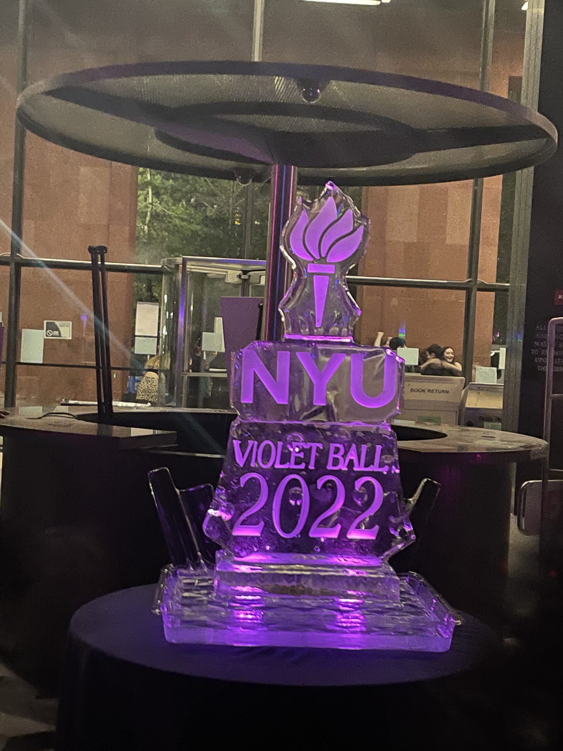 A violet ice sculpture that reads, “NYU Violet Ball 2022.”
