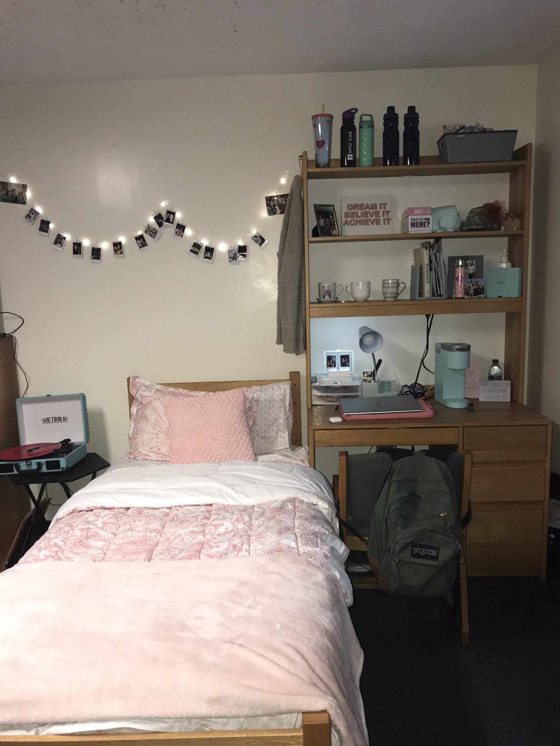 Morgan's first-year residence set up featuring a bed, a well-stocked bookcase and desk, and fairy lights.
