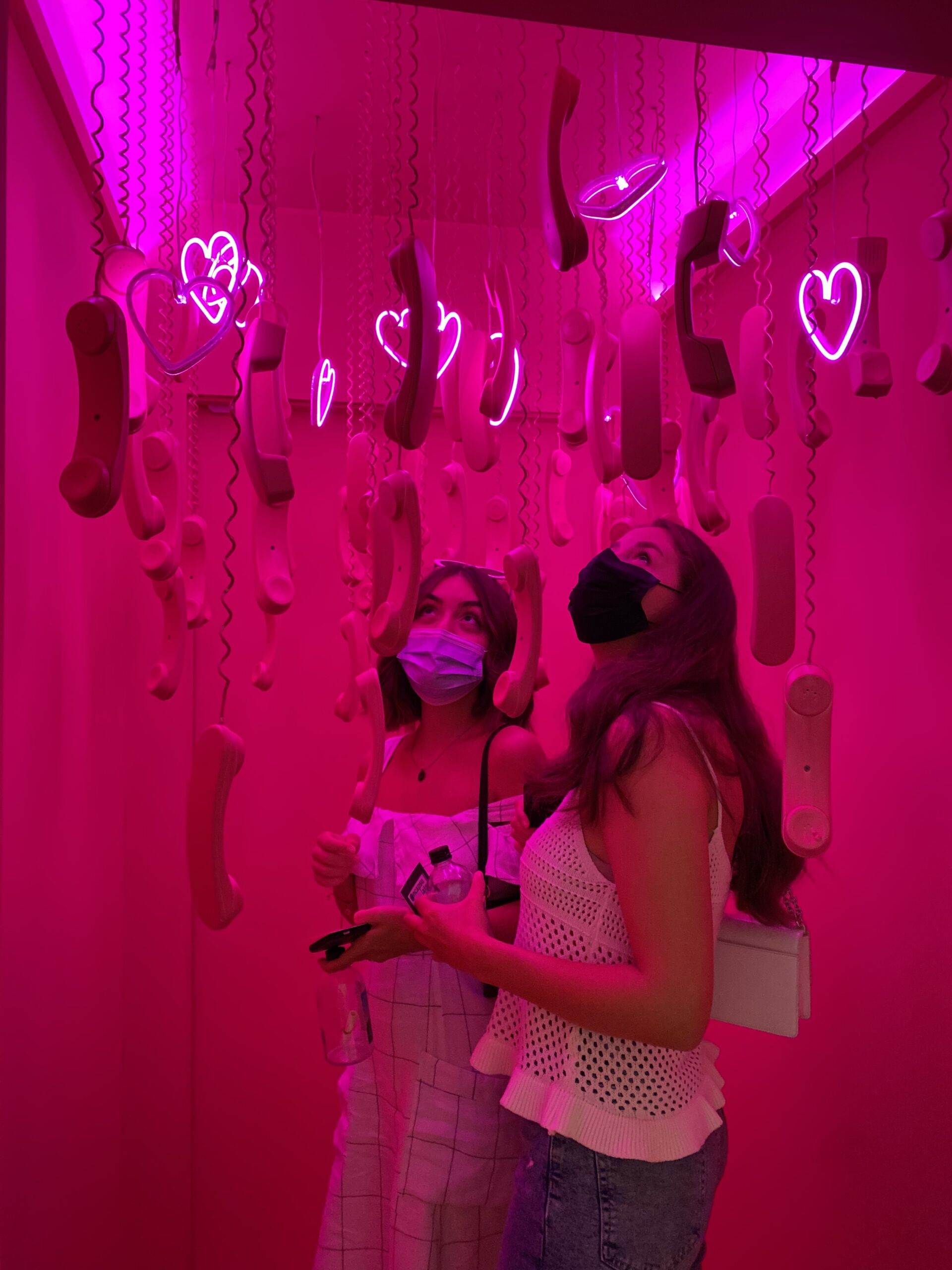 Amina and a few friends are in a bright pink room in an art gallery