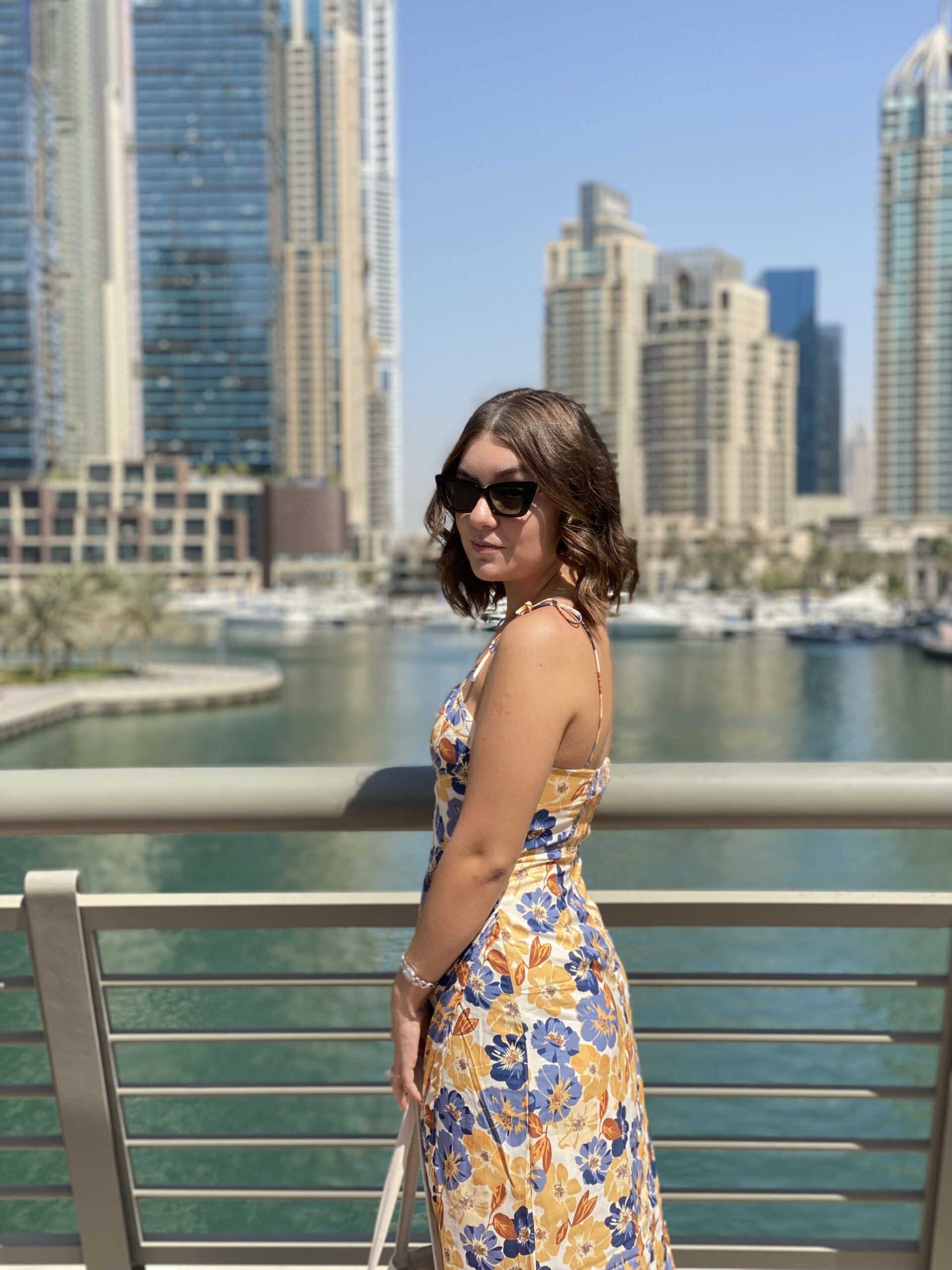 Amina poses in a dress in front of the Dubai skyline