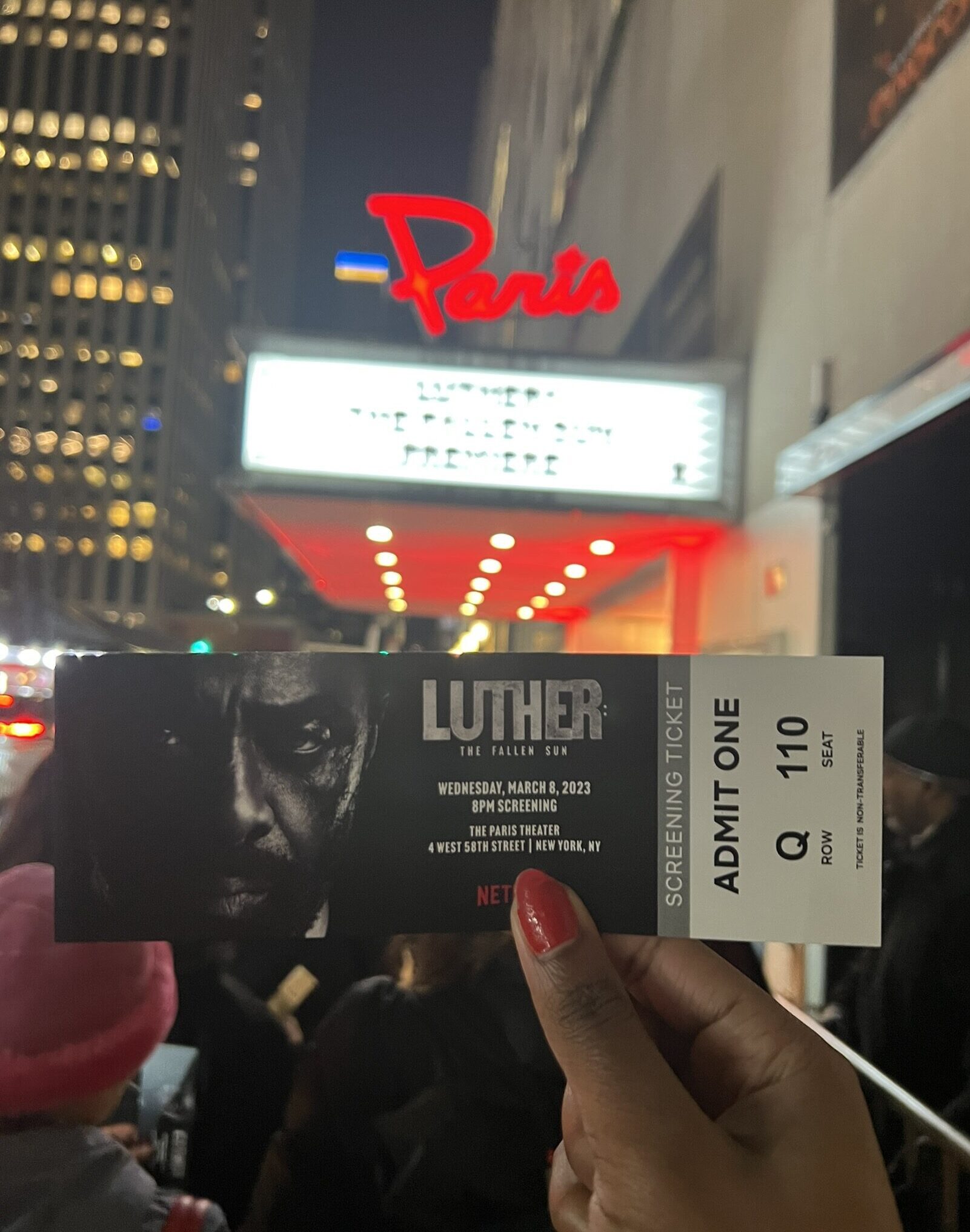 The author holds their free ticket to the red-carpet screening of “Luther” in front of the Paris Theater’s marquee.