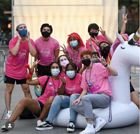 6 students in pink sit on a unicorn during welcome week