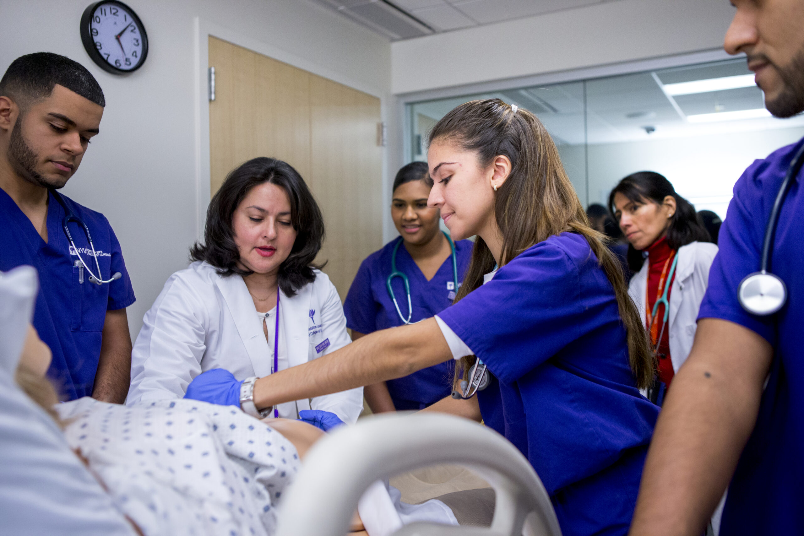 Nursing students working with a professor in the NYU Clinical Simulation Learning Center.