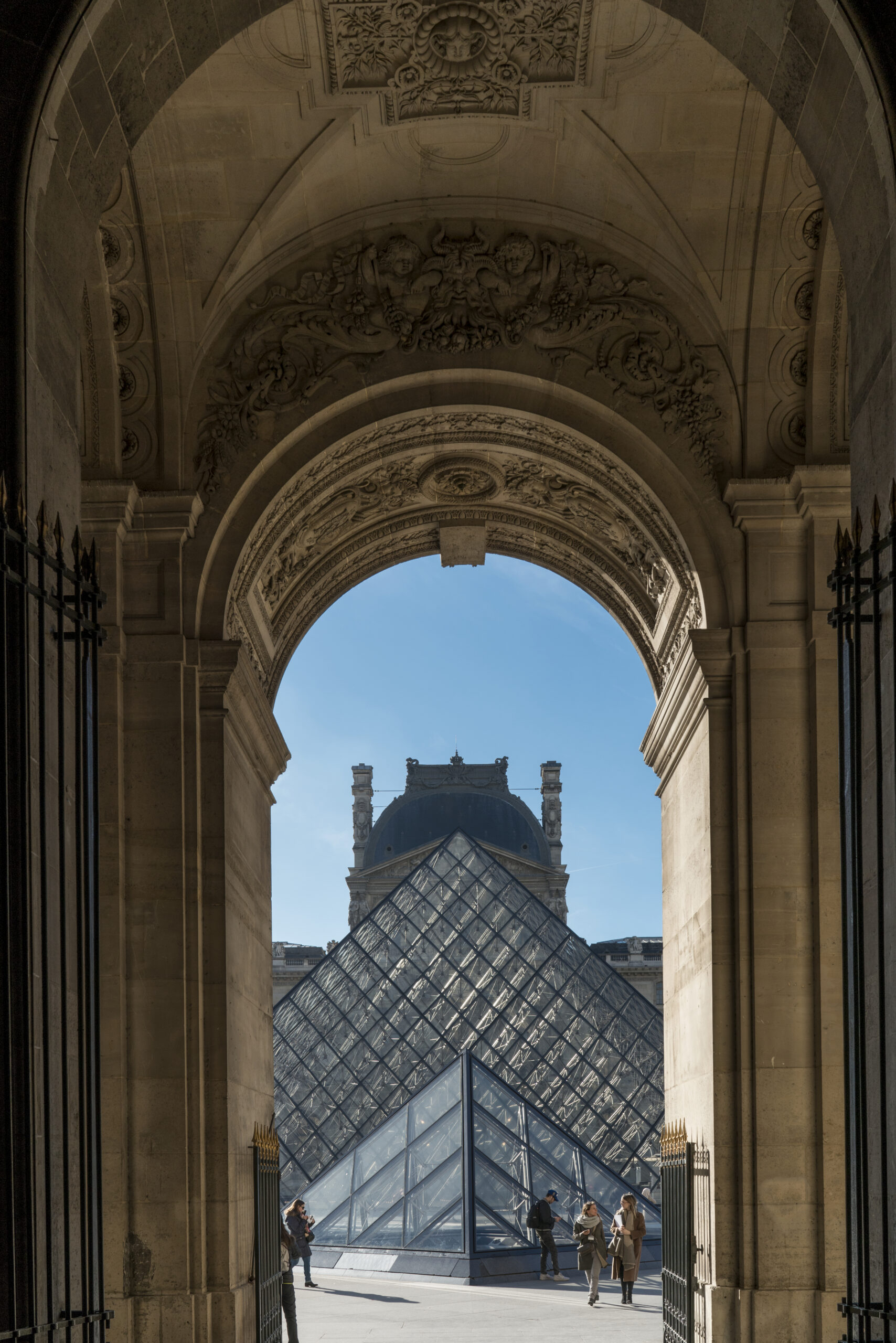 A view of the Louvre from inside an archway.