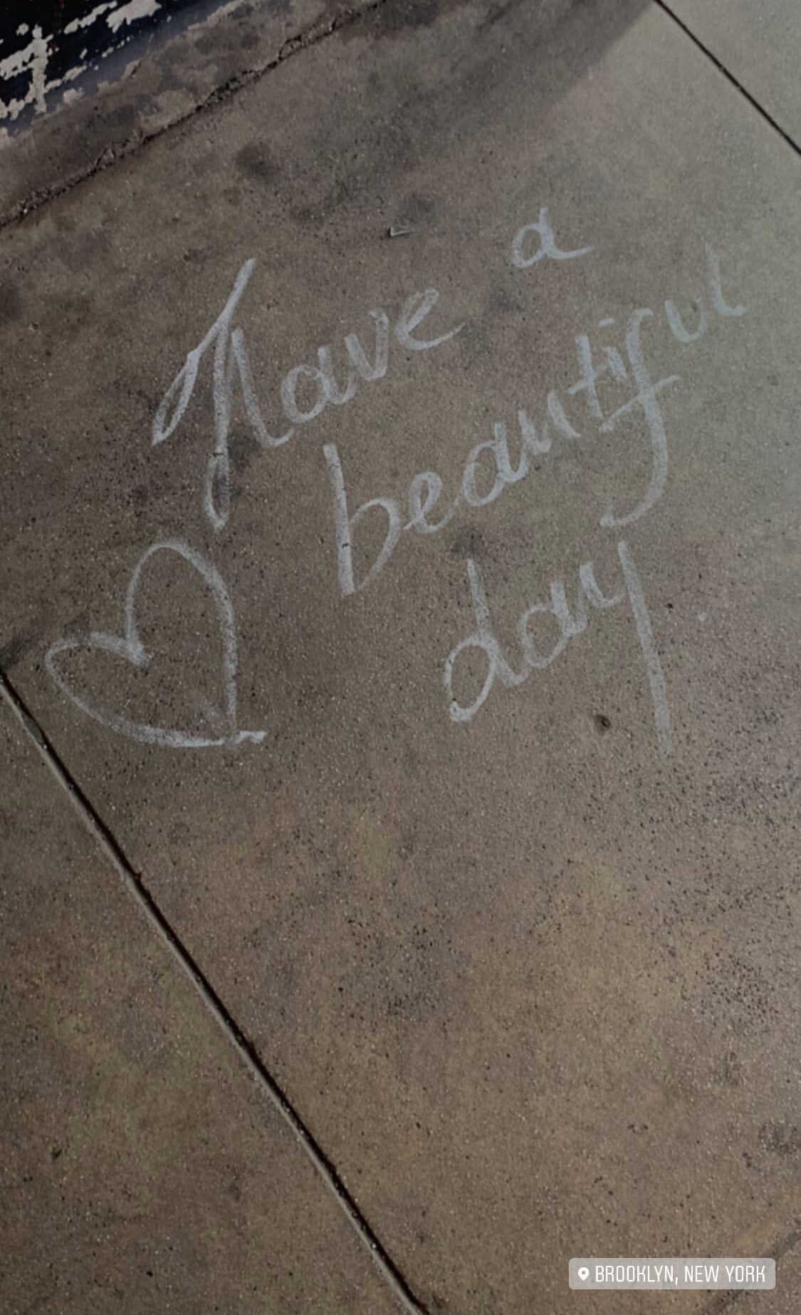“Have a beautiful day” written on a sidewalk in chalk.