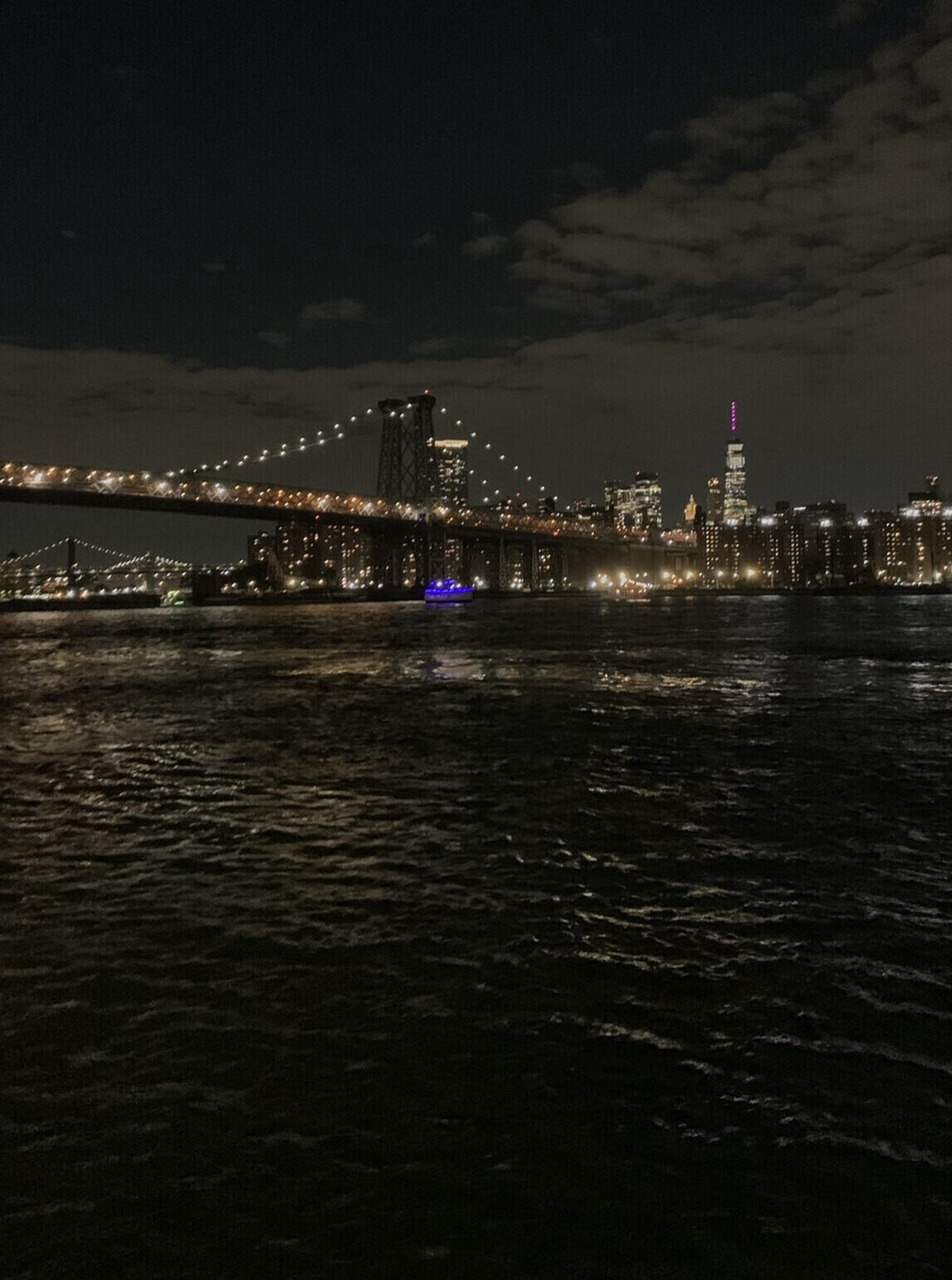 The city skyline with a bridge from the East River at night.