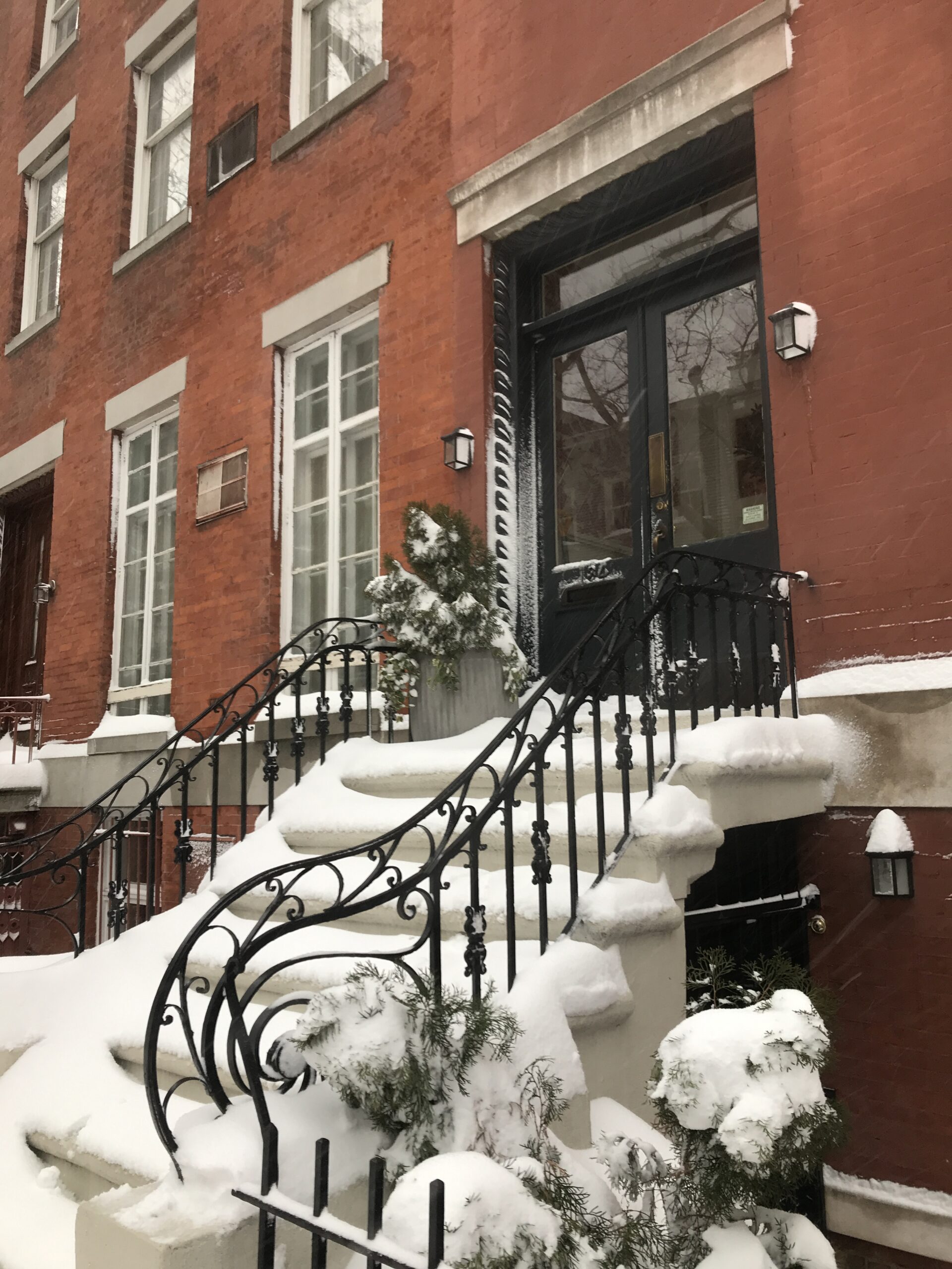 A typical New York City brownstone steps covered in snow.