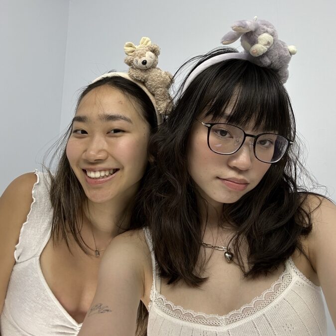 Two NYU students of color wearing stuffed-animal headbands.