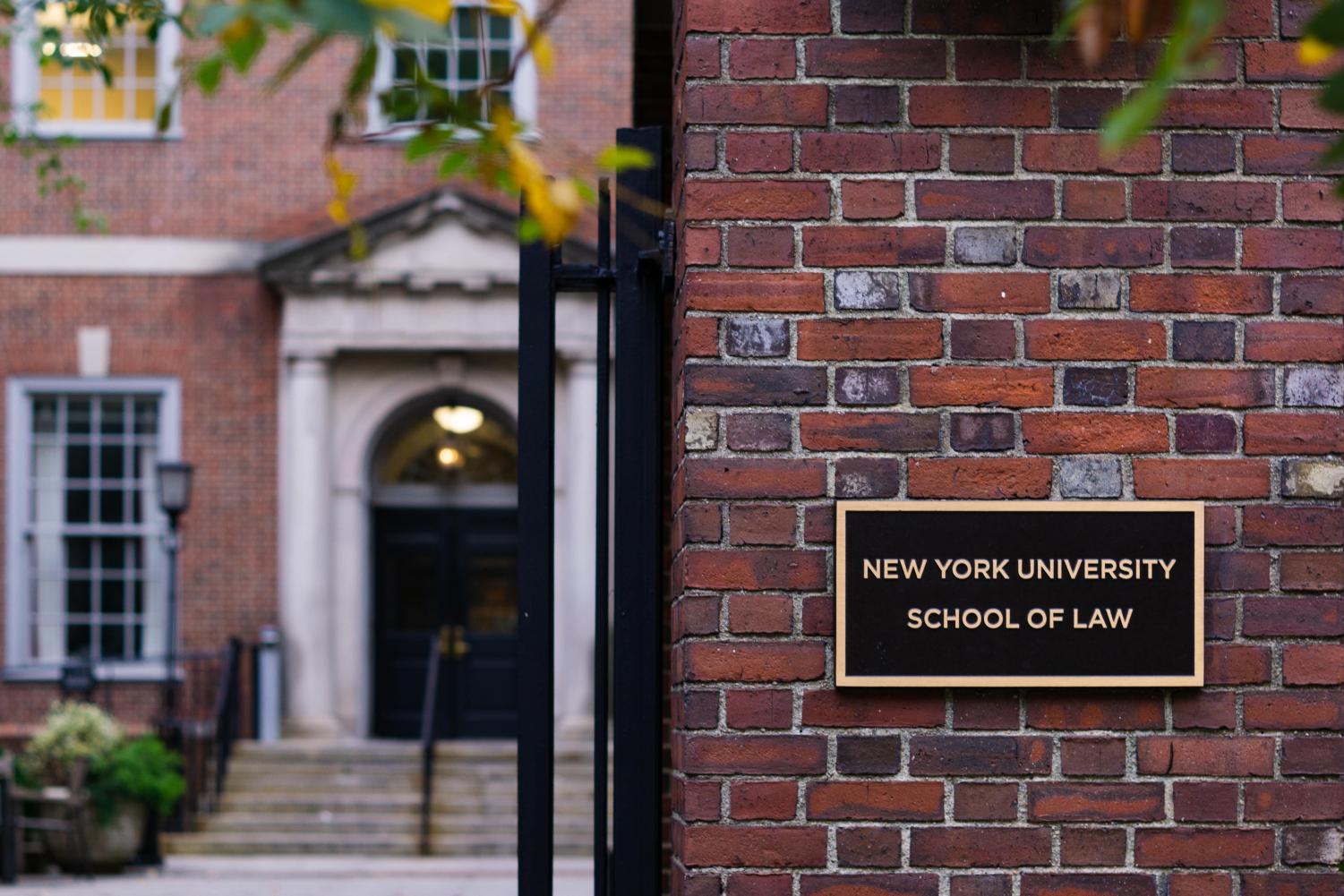 NYU School of Law plaque on brick wall.