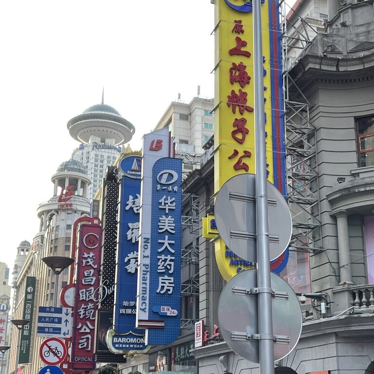 Street signs hang from buildings in Shanghai, China.