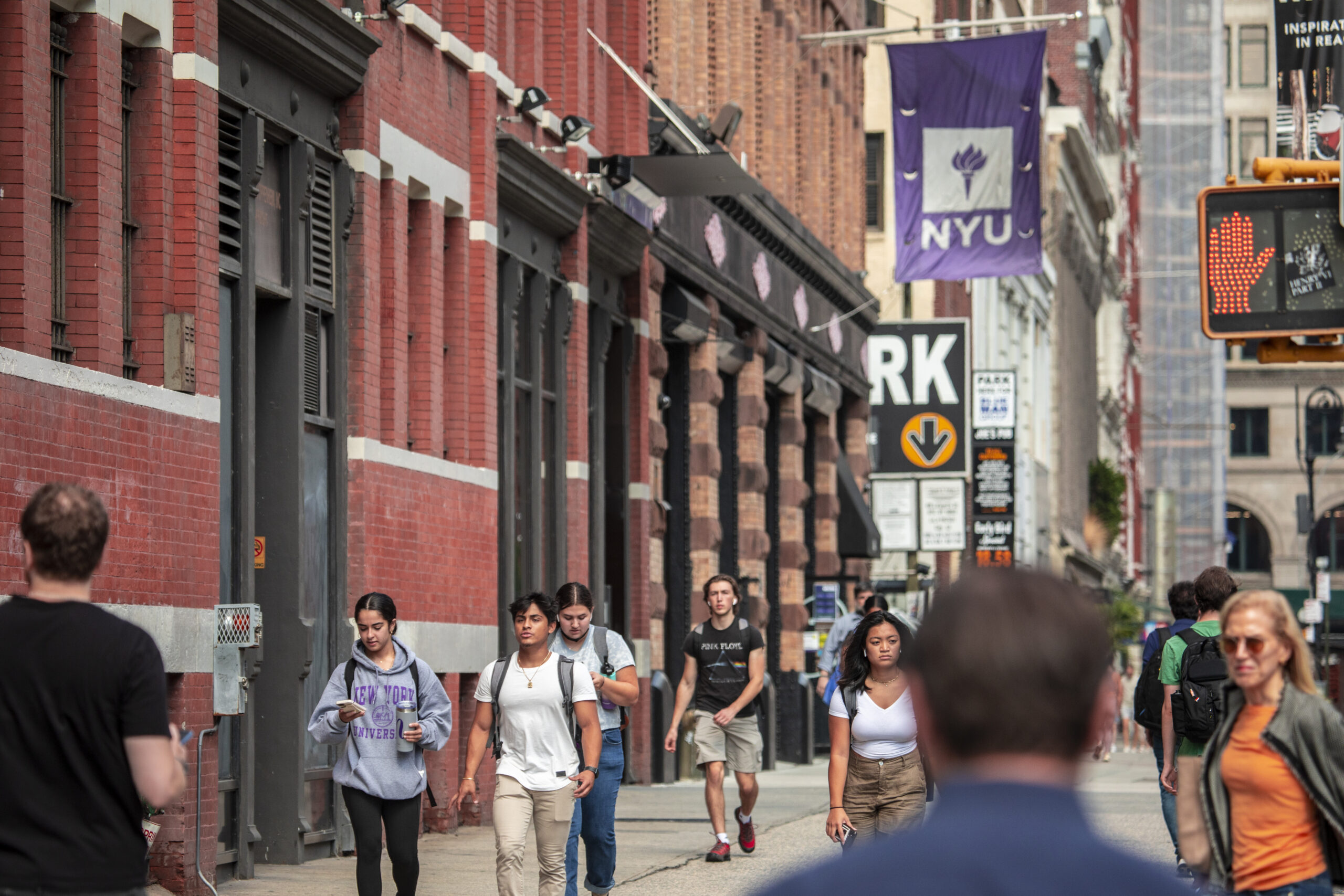 Students on a busy street on NYU’s campus in New York City.