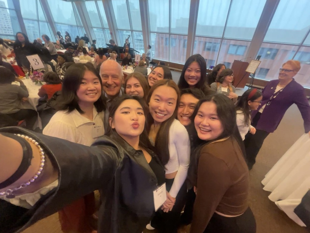A group of nursing students with former NYU president Andrew Hamilton at an event.