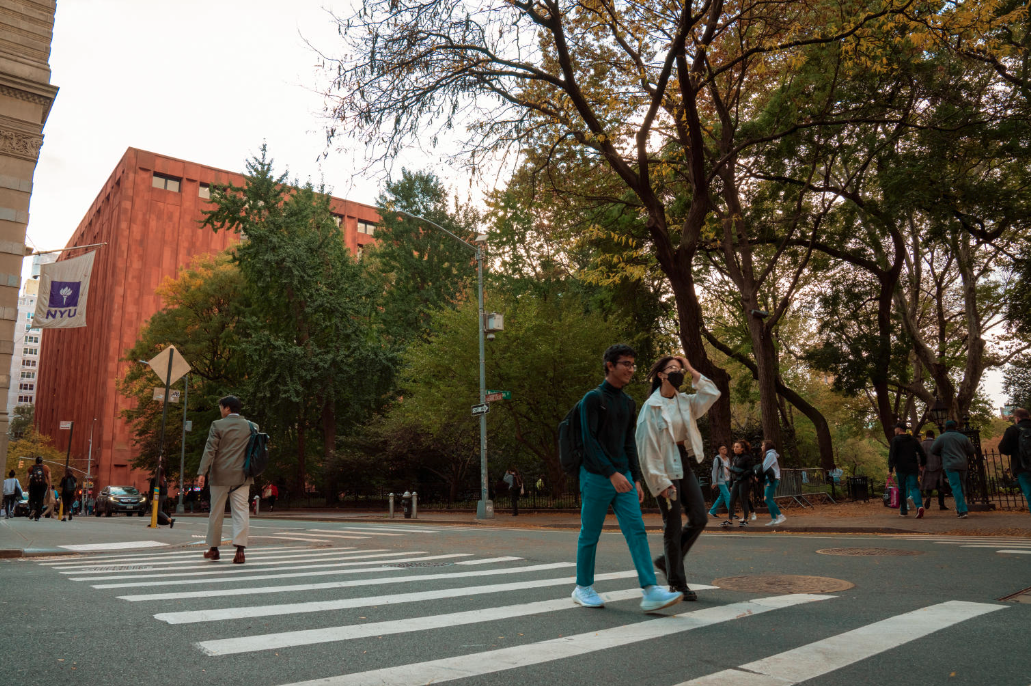students cross a crosswalk near campus