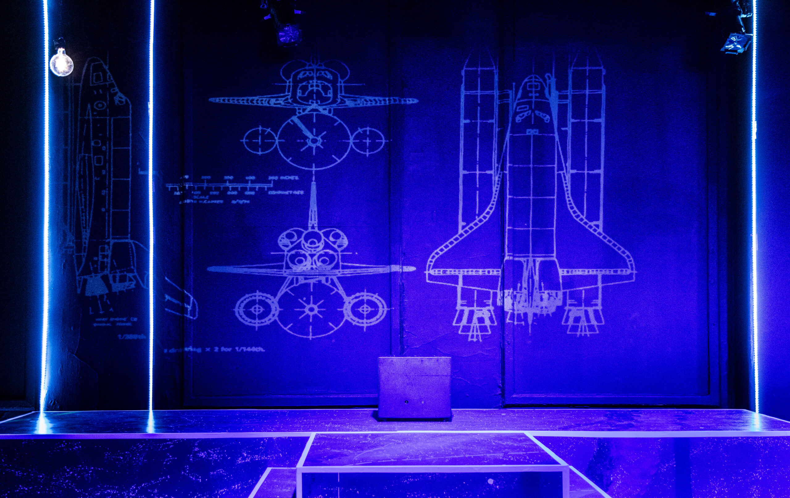 A projection of a spaceship on the stage’s backdrop for the production.